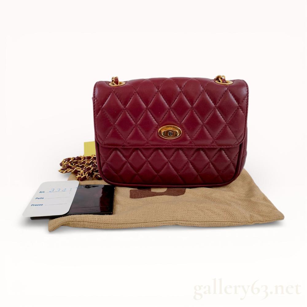 Description
Bally vintage quilted leather shoulder bag in a burgundy oxblood tone, made in Italy. This item features diamond-quilted leather construction with gold-tone hardware, a chain-link strap interwoven with leather, and a turn-lock closure with an embossed B logo. The interior is stamped BALLY and BALLY MADE IN ITALY in gold lettering and is accompanied by a branded tan dust bag, a leather-sleeved mirror, and an Art. 3341 identification card.
Width: 7.5 inches
Height: 6 inches.