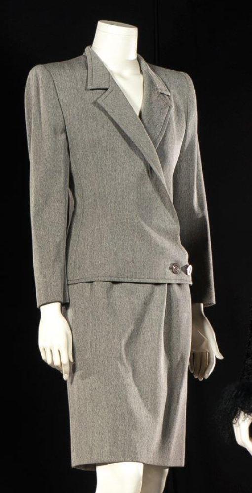 VALENTINO

Couture, circa 1990 Tailleur en whipcord gris, veste à col cranté, boutonnage asymétrique à deux boutons sur patte, manches longues, jupe droite. Griffe blanche, graphisme noir