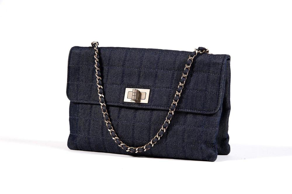CHANEL

Sac 25cm en denim bleu matelassé à deux soufflets, fermeture signée sur rabat, poignée chaîne en métal argenté vieilli entrelacée de jean. Très bon état