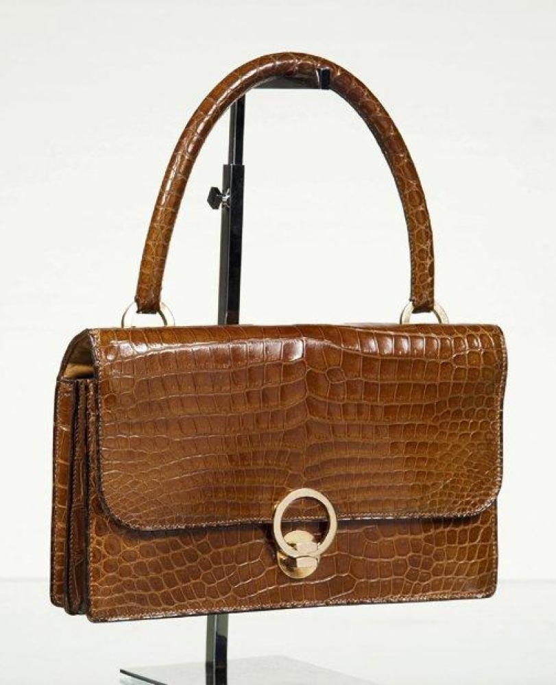 HERMES Paris

Sac "Ring" en crocodile porosus camel à deux soufflets, attaches et fermoir sur rabat plaqué or, poignée. Bon état (Traces de stylo, tâches intérieures, usures aux coins).