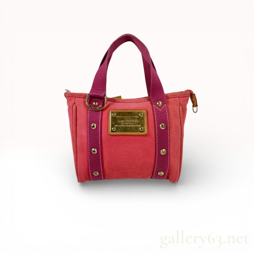 Description
Louis Vuitton Antigua Cabas PM tote bag in rose and magenta toile canvas, circa 2005. The design features a heavy-weight canvas body with contrasting straps, yellow topstitching, and decorative gold-tone brass rivets embossed with the brand name. It includes a metal Louis Vuitton Inventeur plaque on the front and a striped textile interior with a single flat pocket.
Width: 9 inches.