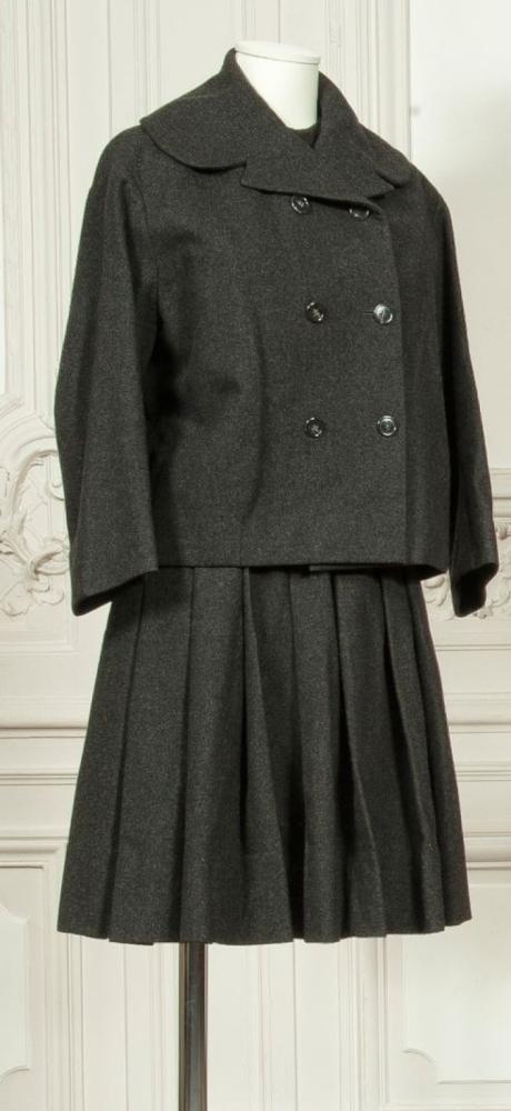 Christian DIOR haute-couture circa 1955

Ensemble en flanelle grise composé d’un haut ras-du-cou à épaule tombante, jupe plissé se porte avec une veste ample à col cranté arrondis, double boutonnage manches longues. (transformation) Griffe noire, graphisme blanc. Planche 50