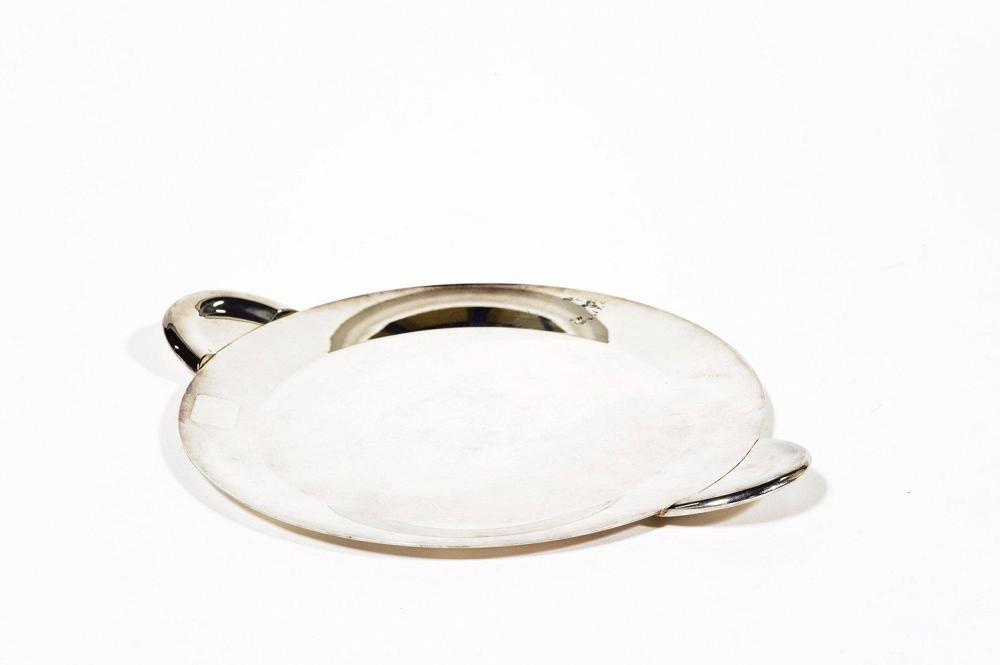 HERMES Paris

Assiette plate en métal argenté figurant un petit plateau circulaire à prises moulées. Bon état