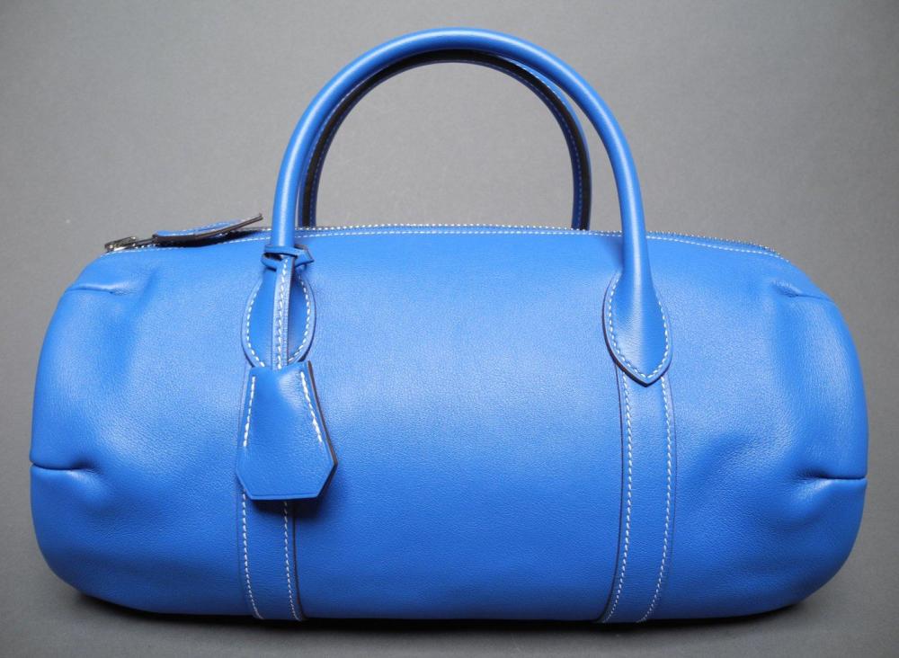 HERMES

Sac "POLOCHON" en cuir swift bleu Double anses porté main Avec son cadenas et ses clés sous clochette en métal argenté L: 30 cm Dans sa housse EN TRES BON ETAT