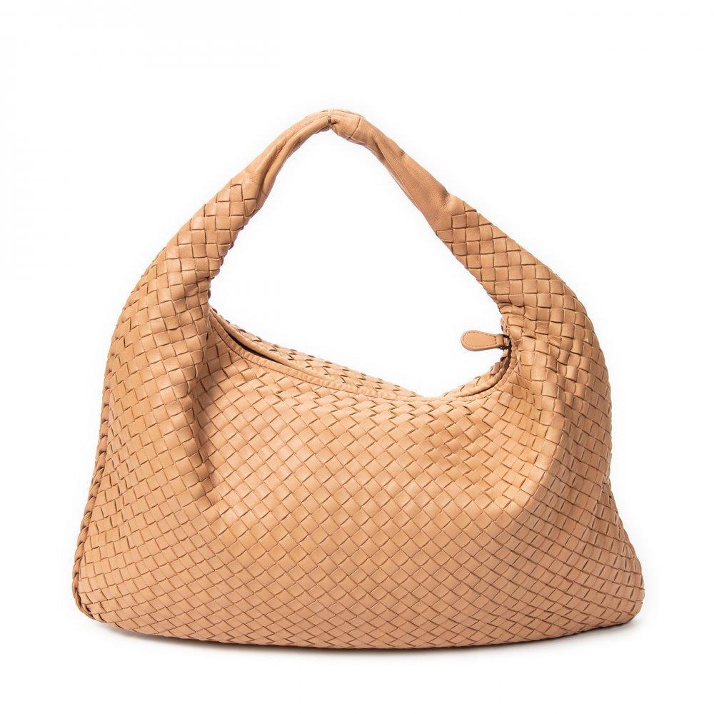 Description

BOTTEGA VENETA.
Veneta Hobo bag.
High-quality nrihr-colored Intrecciato leather, with the brand’s distinctive handcrafted braiding. Short handle that offers a sophisticated and modern style ideal for everyday or for more elegant looks, maintaining the minimalist and luxurious aesthetic of Bottega Veneta. Zipper closure. Antiqued brass hardware.
With interior numbering.
In excellent condition, light signs of use.
Measurements: 40 x 25 x 3 cm.

The Italian brand Bottega Veneta was founded by Michele Taddei in 1966, when the company started producing handcrafted leather goods. The firm created the design made with interlocking leather, ’Intrecciato’, offered on most of its luxury handbags. The simple name ’Bottega Veneta’ translates as "Venice store", which perfectly reflects its understated style. Bottega’s bags do not feature extravagant designs or flashy logos, but rather are elegant and simple. Their bags were famously monogrammed in the 1970s, leading to their famous slogan: "When your own initials are enough."