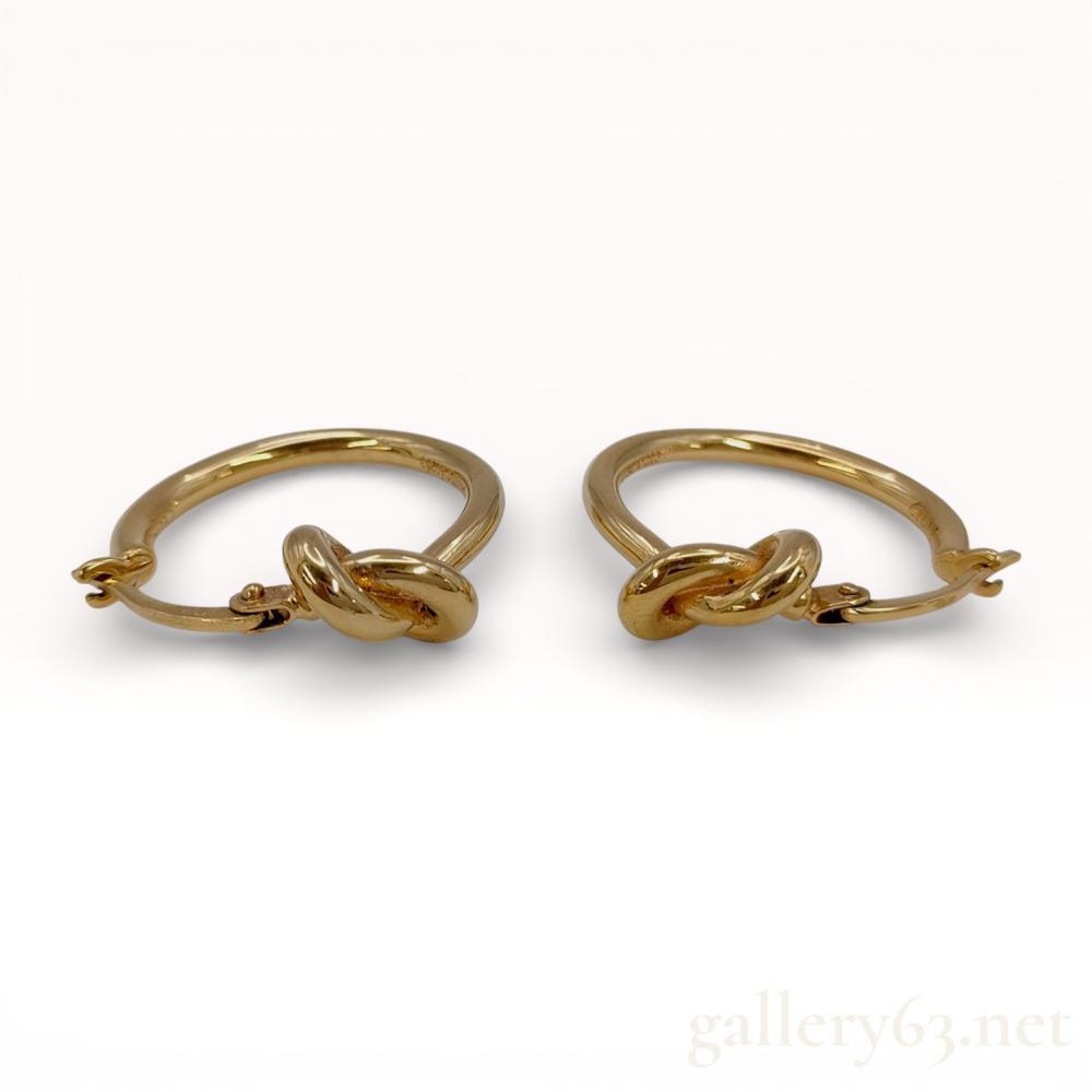 Description
Celine Knot Small Hoops in brass with a gold finish, contemporary. This matched pair of earrings features a central overhand knot motif integrated into a hoop design with hinged lever-back closures. The interior of the hoops is incised with CELINE PARIS, MADE IN ITALY, and the alphanumeric string SGA0253.
Diameter: 2.5 cm.