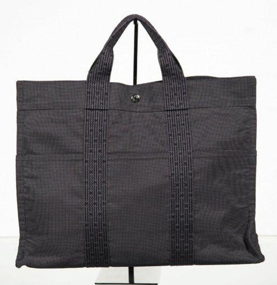 HERMES PARIS MADE IN FRANCE

Sac "Toto bag" en toile chiné anthracite, fermeture pressions, double poignée sangle bicolore, poches extérieures. Bon état (légères traces à la base)
