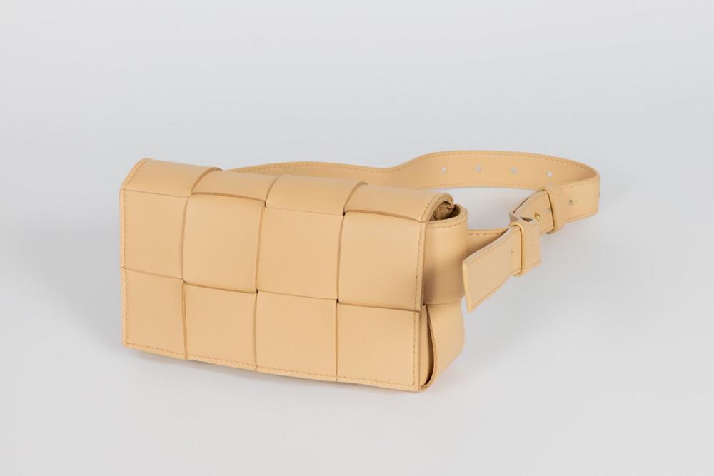 Description

BOTTEGA VENETA
Cassette bum bag.
In cream leather with Intrecciato maxi finish. Magnetic flap closure and adjustable handle. Inside with pocket.
Measurements: 19 x 10 x 5 cm.
Bottega Veneta’s Cassette fanny pack is one of the most emblematic reinterpretations of the brand’s heritage in a contemporary key. Inspired by the historic intrecciato motif, a leather weaving technique developed by the house since the 1960s, this piece amplifies its proportions to turn the braiding into a volumetric element. Introduced during the brand’s creative phase of aesthetic renewal in the 21st century, the Cassette line reflects a commitment to formal simplification and the exaltation of the material, where leather takes on absolute prominence.