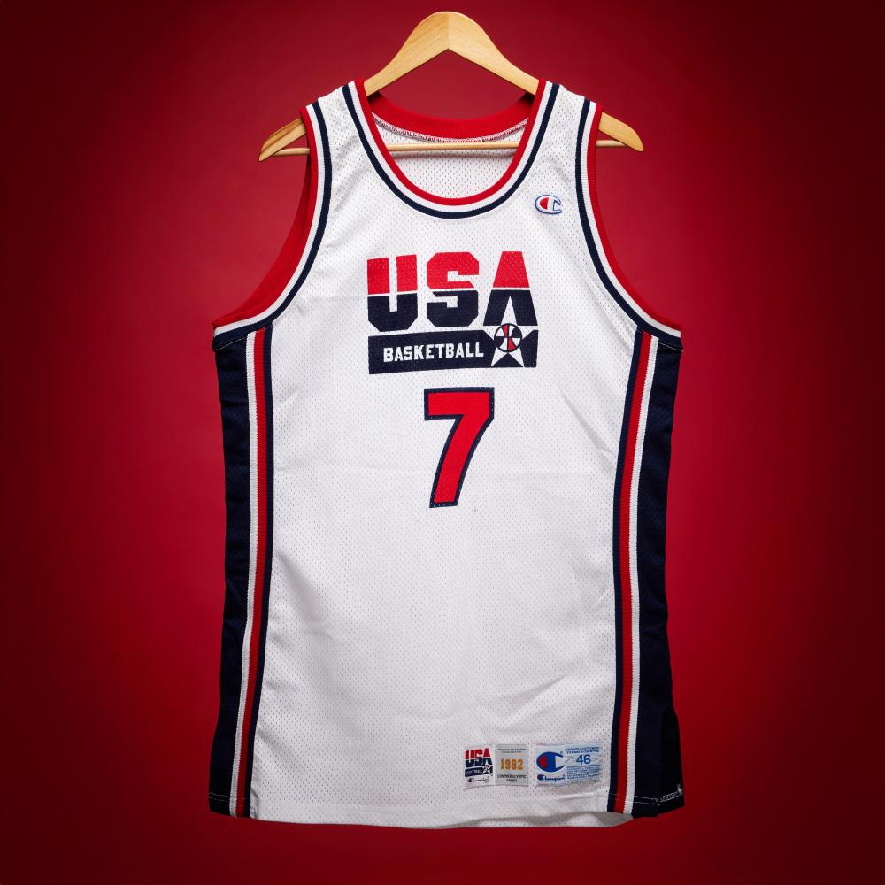 Larry Bird Game Worn and Signed 1992 Olympics ‘Dream Team’ Jersey | Gold Medal Run

CHAMPION, USA BASKETBALL 1992 SUMMER OLYMPIC GAMES JERSEY, SIZE 46

1992

“My family were huge Olympic fans. As a kid it was all we watched every night. We’d heard about the plans to admit professional basketball players, but I never knew if it was going to happen. I was very happy it did, and I got the opportunity to play. It was something you always dreamt about.” – Larry Bird on being selected for the 1992 Dream Team

Sotheby’s is proud to present Larry Bird’s game-worn jersey from the 1992 Olympic Games in Barcelona. As co-captain of the Dream Team, Bird was both a symbol of American basketball and a guiding presence for a roster that permanently reshaped the global game. This jersey was worn on August 2, 1992, during the final group stage game against Spain. Team USA won 122–81, with Bird contributing 14 points, 4 rebounds, 3 assists, and 2 steals. Beyond the statistics, his presence steadied the team, reinforced its culture, and demonstrated the veteran leadership that defined the Dream Team. Reflecting on the achievement, Bird later said, “Winning the gold medal has to be one of the greatest things you can ever do as an athlete.”

By the summer of 1992, Bird was nearing the end of a Hall of Fame career. Battling chronic back issues, he arrived in Barcelona far from full health. Early reports suggested he might withdraw from the tournament, but he instead delivered on the court. In the team’s third game, he scored 19 points against Germany in 21 minutes, a reminder that his basketball instincts and shooting touch remained sharp even under physical strain.

Bird’s Olympic experience was deeply personal. Growing up in a household that revered the Olympics, representing the United States fulfilled a lifelong dream. “It was something you always dreamt about,” he said. This jersey, worn in his only Olympic appearance and during the final chapter of his playing career, captures that moment. Game-worn Dream Team jerseys are rare, and examples worn by Bird are virtually nonexistent in the marketplace.

The 1992 United States Men’s Olympic Basketball Team is widely regarded as the most influential assembly of talent in the history of sport. It marked the first time NBA players competed in the Olympics, changing how the world saw the game. Led by Scottie Pippen, Michael Jordan, Magic Johnson, and Larry Bird, the roster combined multiple generations of talent. Pippen anchored the team with his defense and playmaking, Jordan set the competitive tone, and Magic’s return carried cultural significance. Bird provided veteran leadership and shooting. Other teammates include Charles Barkley, Karl Malone, John Stockton, David Robinson, Clyde Drexler, Chris Mullin, and Patrick Ewing, all established stars in the NBA.

Coach Chuck Daly recalled, “It was like Elvis and the Beatles put together. Traveling with the Dream Team was like traveling with 12 rock stars. That’s all I can compare it to.”

The team dominated the Barcelona Games, winning all eight contests by an average of over 40 points and capturing the gold medal without serious challenge. This jersey comes directly from the Collection of Scottie Pippen.

This jersey has been photomatched by PSA. The jersey is also accompanied by a letter from James Spence Authentication in regards to the signatures.