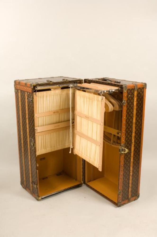 Louis VUITTON

Champs Elysées n°illisible Double malle penderie en toile monogram au pochoir chiffrée A.C.D, bordures lozinées, renforts hêtre, coins, fermetures en laiton doré, poignées cuir, intérieur à penderies complètes avec une ouverture frontale, manque casiers chaussures. Dimensions : 66 x 55 x 110 cm