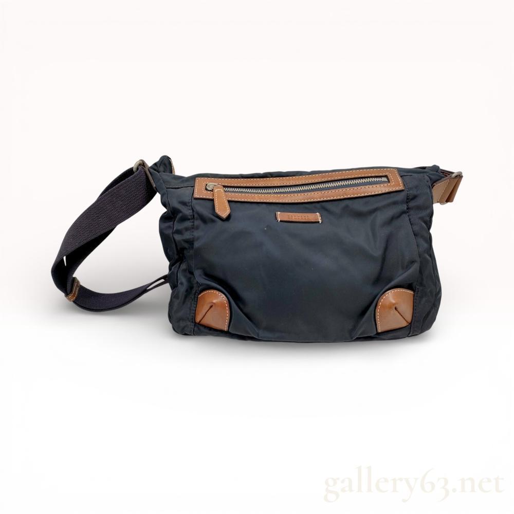 Description
Barneys New York shoulder bag crafted in navy nylon featuring tan leather trim and corner reinforcements. Designed with a front zip pocket, top zip closure, and a wide adjustable woven shoulder strap for comfortable everyday wear. Compact slouchy silhouette with minimal branding.


Navy nylon exterior


Tan leather trim and corner accents


Front zip pocket with leather pull


Top zip closure


Adjustable wide shoulder strap


Soft structured everyday shoulder bag design


Light wear visible to nylon and leather details consistent with handling. Overall clean condition with intact stitching and functioning zippers.