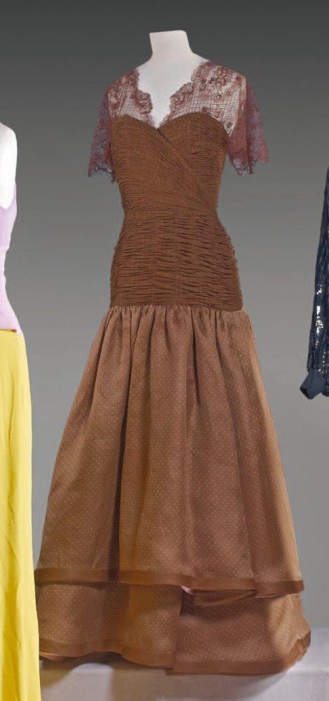 VALENTINO

Robe du soir longue, haut en dentelle marron décolleté en v, sur un drapé en organza marron à pois blanc, soulignant la poitrine préformée, fermeture éclair en biais à effet de cache coeur, jupe ample sur deux niveaux gansés d’organza uni identique au doublage à partir des hanches. Griffe blanche, graphisme marron