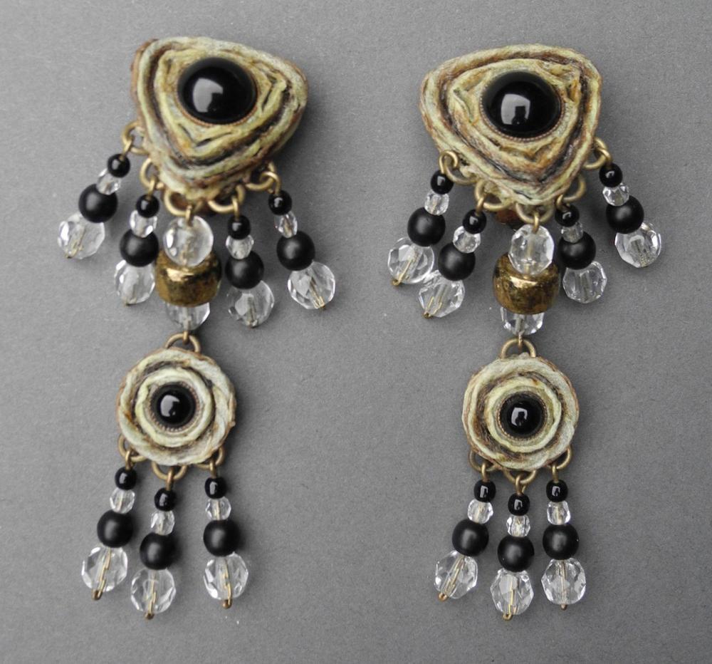 HENRY - circa 1960

Paire de pendants d’oreilles clips en résine gravée et rehaussée de cabochons en pâte de verre noire se finissant par des pendeloques de perles Signée