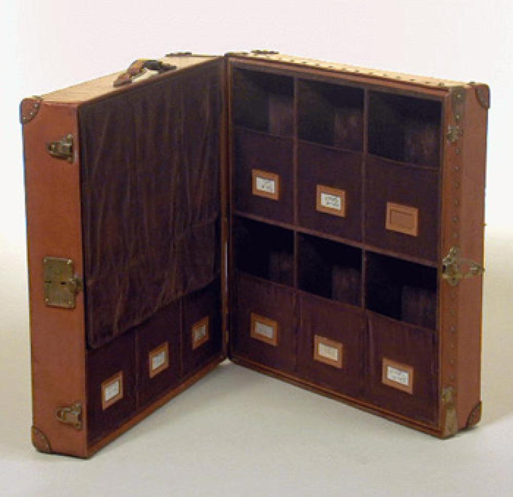Louis Vuitton Custom Leather Shoe Carrier

Lot 1242A
Louis Vuitton Custom Leather Shoe Carrier
 1930s 
 Tan, with leather corners, brass fittings, steamer label, lock no. 063413, the interior fitted with brown velvet compartments with slots for labels, marked: Louis Vuitton. Height 8 inches, width 24 1/2 inches, depth 23 inches.
Very good condition, some wear to exterior.