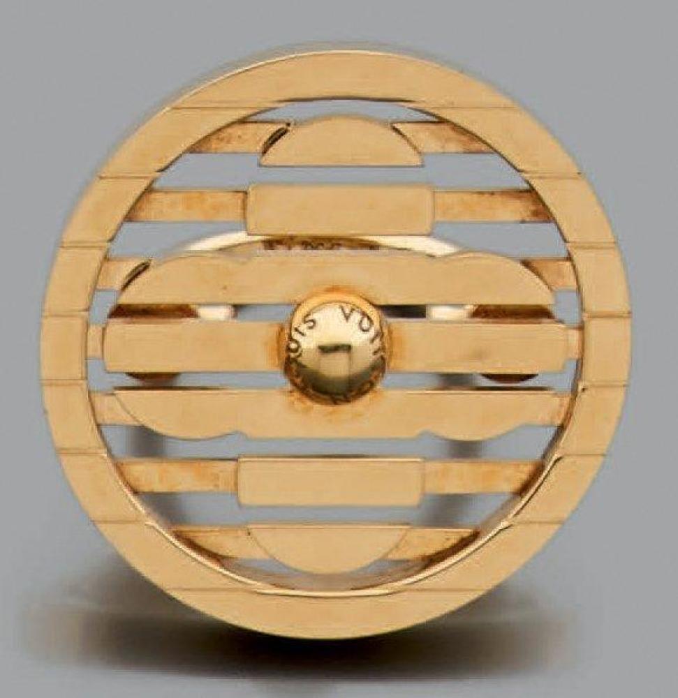 VUITTON

Originale bague en or jaune 18k composée d’un motif rond orné de lignes ajourées laissant resortir une fleur. Signée Poids brut: 27.32gr Tour de doigt: 50