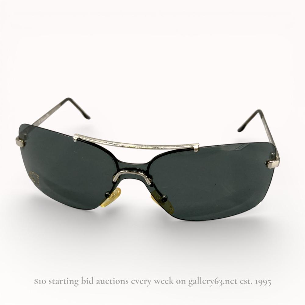 Description
Authentic Christian Dior sunglasses having a shield-style dark tinted lens set within a black and silver-tone metal frame. Design featuring a curved single lens profile with integrated nose pads and slender metal temples. Temples stamped with Dior branding. Modern wrap silhouette presented as a standalone pair.