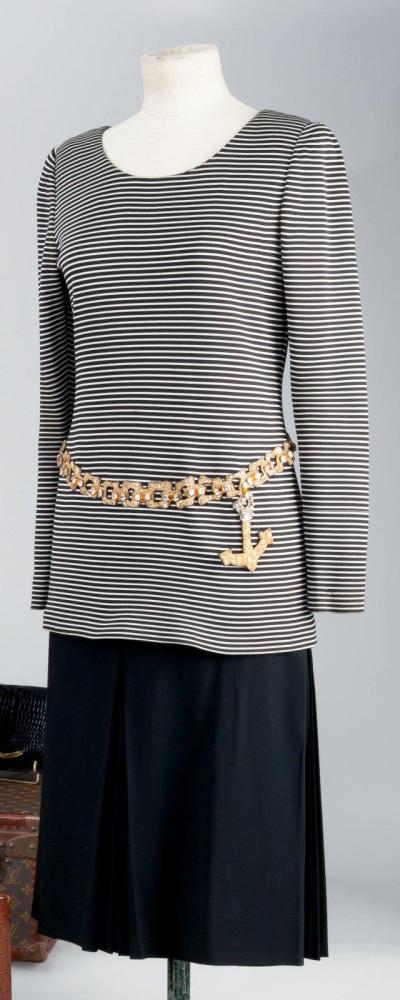 Guy LAROCHE

haute couture circa 1968/1970Marinière en jersey de soie écrue à rayures noires encolure bateau,manches longues, effet de ceinture en trompe oeil par une application de passementerie formant des anneaux ornés de strass et finissant par une ancre, se porte sur une jupe en lainage sable à plis creux sur le devant. Sans griffe (salissures)