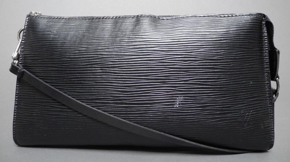 Louis VUITTON

Pochette accessoires en cuir épi noir frappé des initiales LV Fermeture zippée en métal argenté Anse amovible en cuir lisse noir Intérieur en tissu noir 24 x 13 cm Etat d’usage (tâches et griffures)