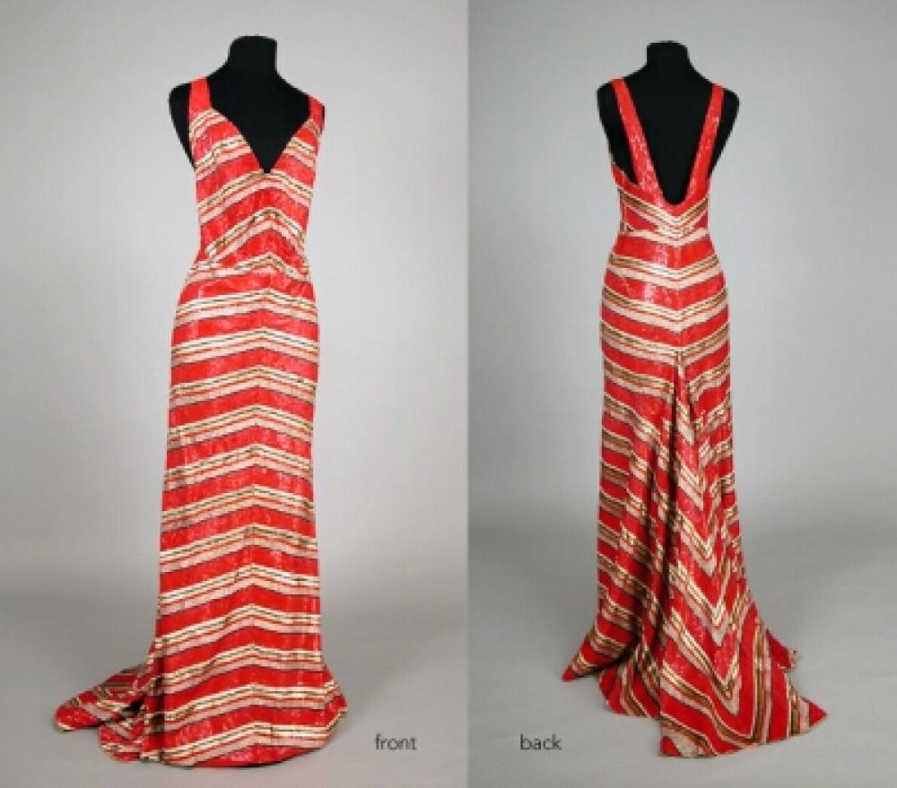 Striped Sequin Evening Gown

Lot 517
Striped Sequin Evening Gown
 Probably Worth, French, 1930s 
 Camisole bodice with low V front and back, silk solidly sewn with micro sequins and beads forming red, gold and black stripes arranged horizontally on slight diagonal, peach silk lining with flounce, size 8. 
Very good condition, alteration, probably cut, at waistline.