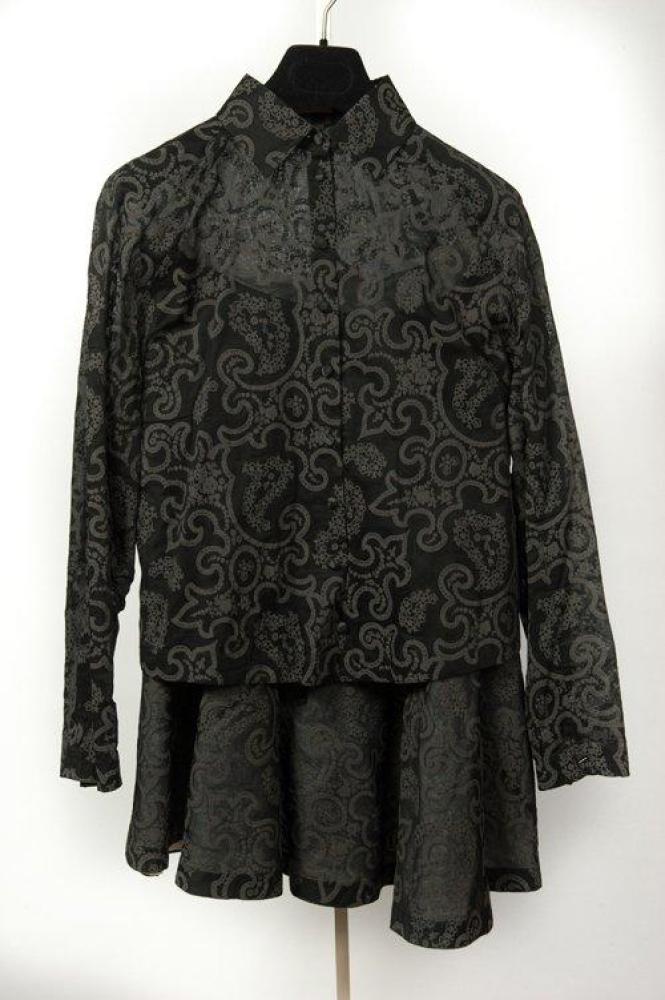 ALAÏA circa 2006/2007

Ensemble en composite gommé gris, noir à motif végétal, composé d’une blouse à petit col, manches longues et jupe ample doublée du même matériaux blanc, Griffe beige, graphisme blanc.