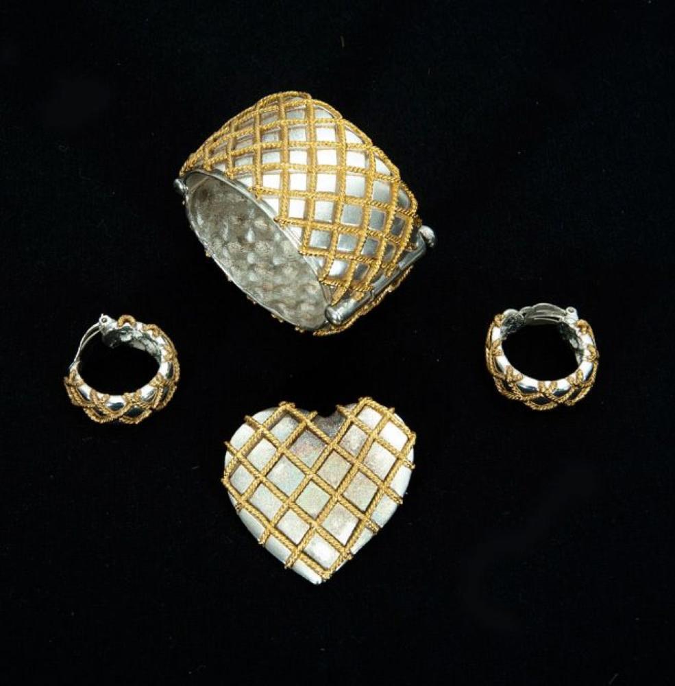 Yves SAINT LAURENT Made in France

Parure en métal argenté à effet matelassé en métal doré comprenant un bracelet manchette ouvrant, une broche coeur, une paire de demi-créole. Signés