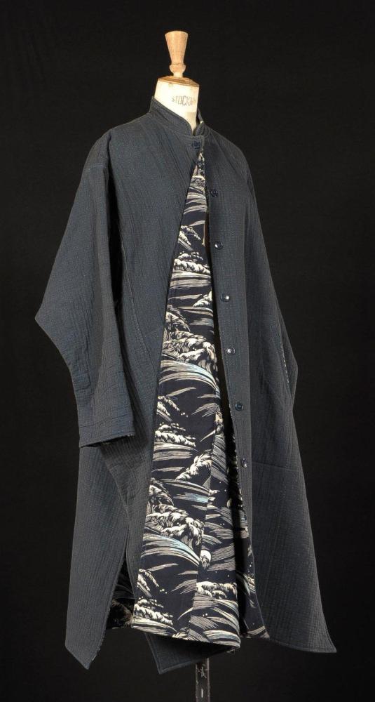 KENZO, circa 1980

Ample manteau s’inspirant des vestes japonaises en coton matelassé, noir, bleu, ecru, petit col droit, simple boutonnage, deux poches en biais, manches longues marteaux, partiellement doublé d’une toile imprimée s’inspirant de la vague de Hokusaï.