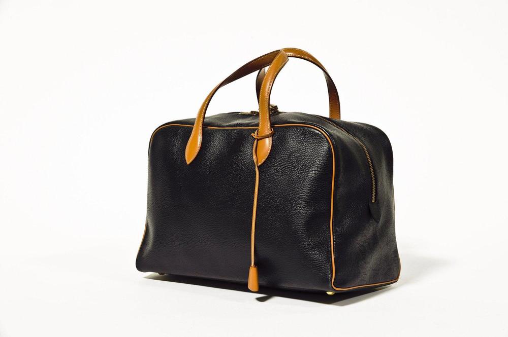 HERMES Paris made in France

Sac "Victoria" de voyage 44cm en cuir grené noir et cuir gold à surpiqûres blanches, fermeture éclair à double curseur, double poignée, clefs, cadenas. Bon état (légères usures aux coins)