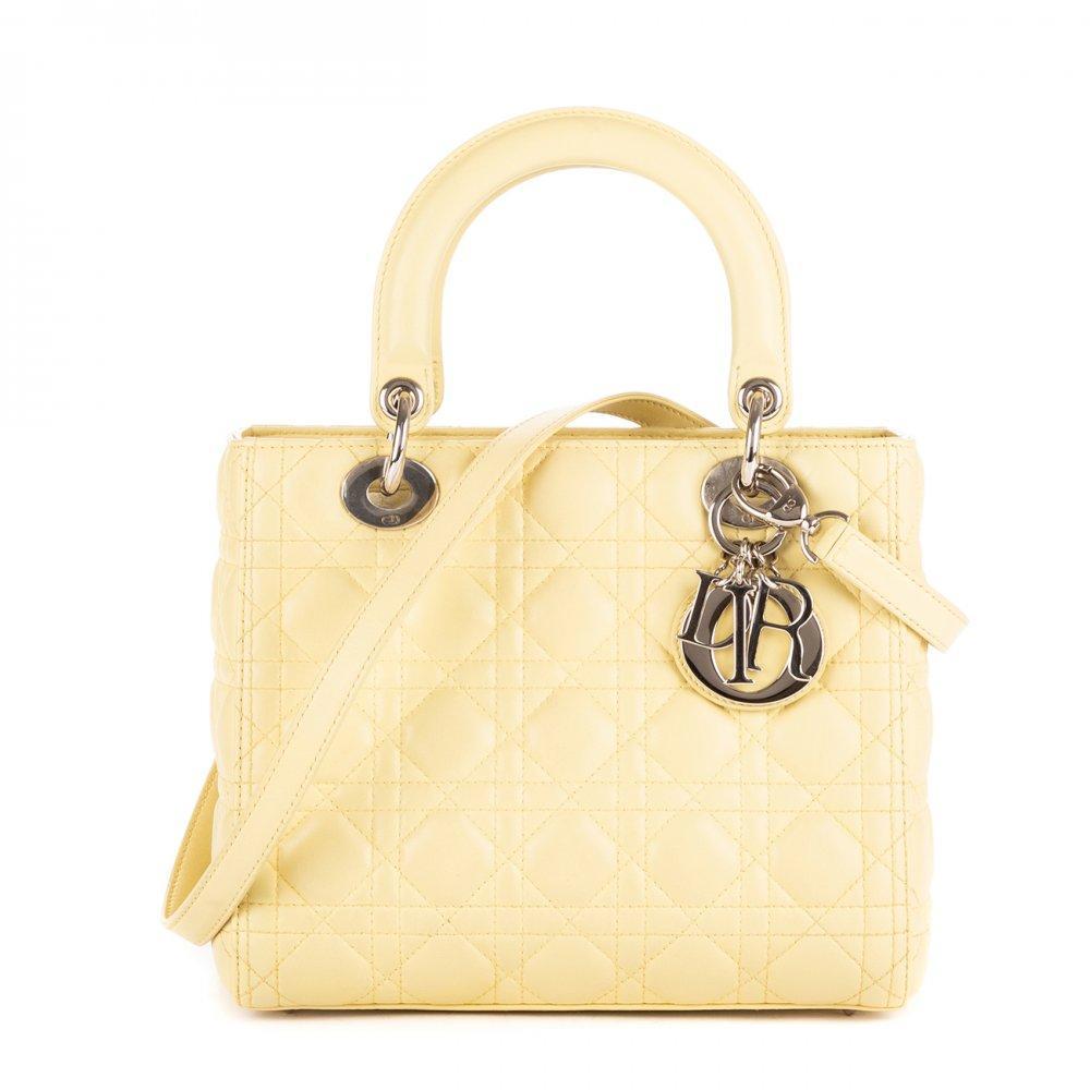 Description

DIOR.
Medium Lady-D bag.
Yellowish cream leather with iconic "cannage" stitching. Silver hardware. D.I.O.R. Charms. Double short top handle. Long removable shoulder strap. Zipper closure. With four protective rivets at base. Interior in the same color.
With interior numbering.
In perfect condition, barely unused.
Measurements: 24 x 21 x 10 cm.

The Lady Dior is, without a doubt, one of the most emblematic bags in the history of fashion. Launched in 1994 under the original name "Chouchou", its destiny changed in 1995. It was then that Bernadette Chirac, First Lady of France, gave it as a gift to Princess Diana of Wales during her visit to Paris. Diana Spencer’s love affair with the bag was instantaneous; from that moment on, the princess wore it assiduously on her travels around the world, consolidating its popularity. Given the resounding success of the bag when it arrived in boutiques in January 1996, the Maison decided to officially rename it Lady Dior, an enduring tribute to the iconic Princess of Wales. This coveted accessory comes in a wide variety of materials, ranging from soft lambskin or patent calfskin, to more exotic options such as deerskin, smooth leather, grained leather, crocodile skin, canvas or python skin, among others. Each Lady Dior piece is a handcrafted work of art, requiring the meticulous work of seven craftsmen and a minimum of eight hours of manufacturing. For its elaboration, about 130 pieces must be delicately cut and sewn by hand, which underlines its exclusivity and the mastery behind its creation.