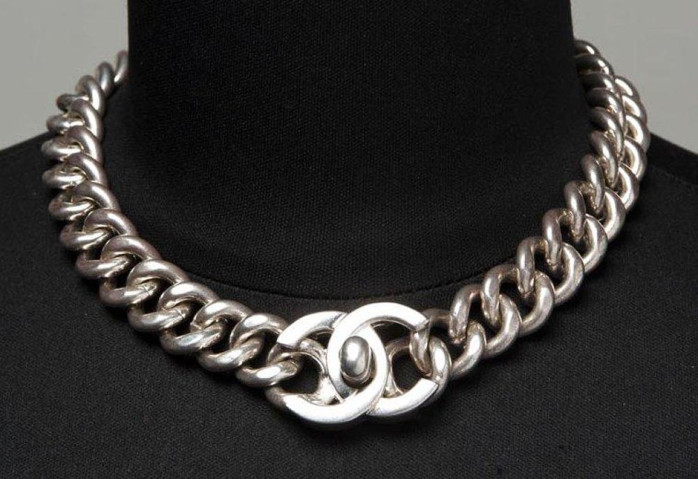 CHANEL, circa 1998

Collier chaine en métal argenté, fermoir figurant le sigle. Signé daté, nous y joignons une paire de boutons de manchettesnfigurant des boutons siglés. Signée