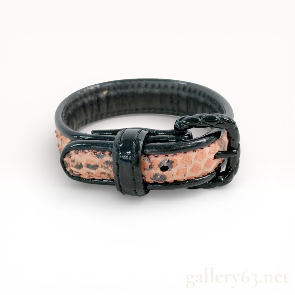 Description
Bottega Veneta buckle-style strap bracelet, size XS. Crafted from black leather with a central natural snakeskin inlay featuring tan and pink tones with dark spotted markings. The black coated metal buckle displays the signature intrecciato braided motif and secures with a single prong and leather keeper. Interior strap is embossed with BOTTEGA VENETA, MADE IN ITALY, and XS.
Size: XS.