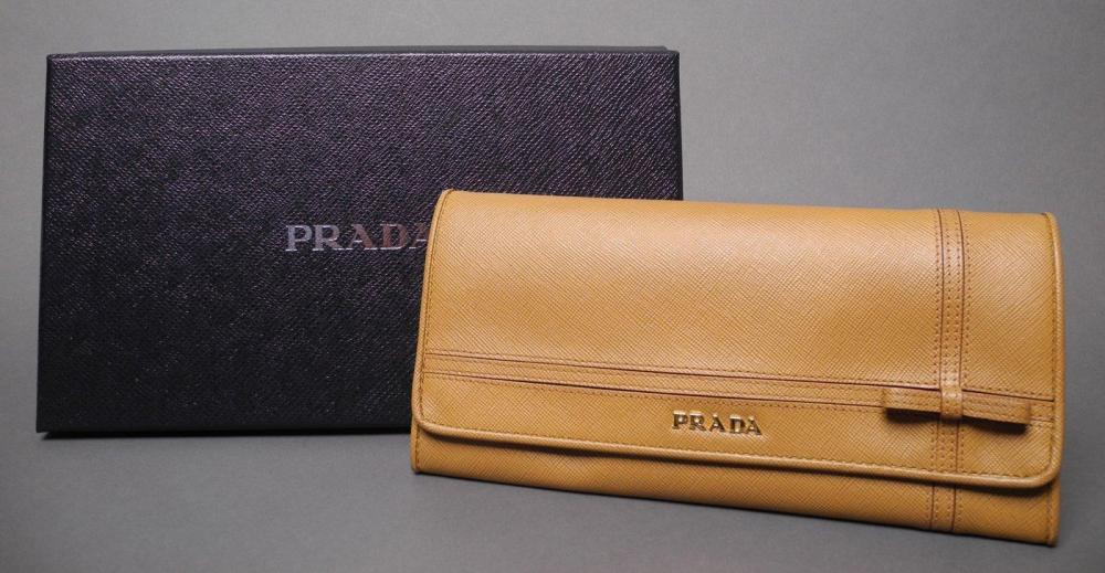 PRADA

Portefeuille en cuir Saffian de couleur caramel orné d’un noeud Rabat siglé en métal doré L: 21 cm ETAT NEUF Dans sa boîte d’origine et avec sa carte d’authenticité
