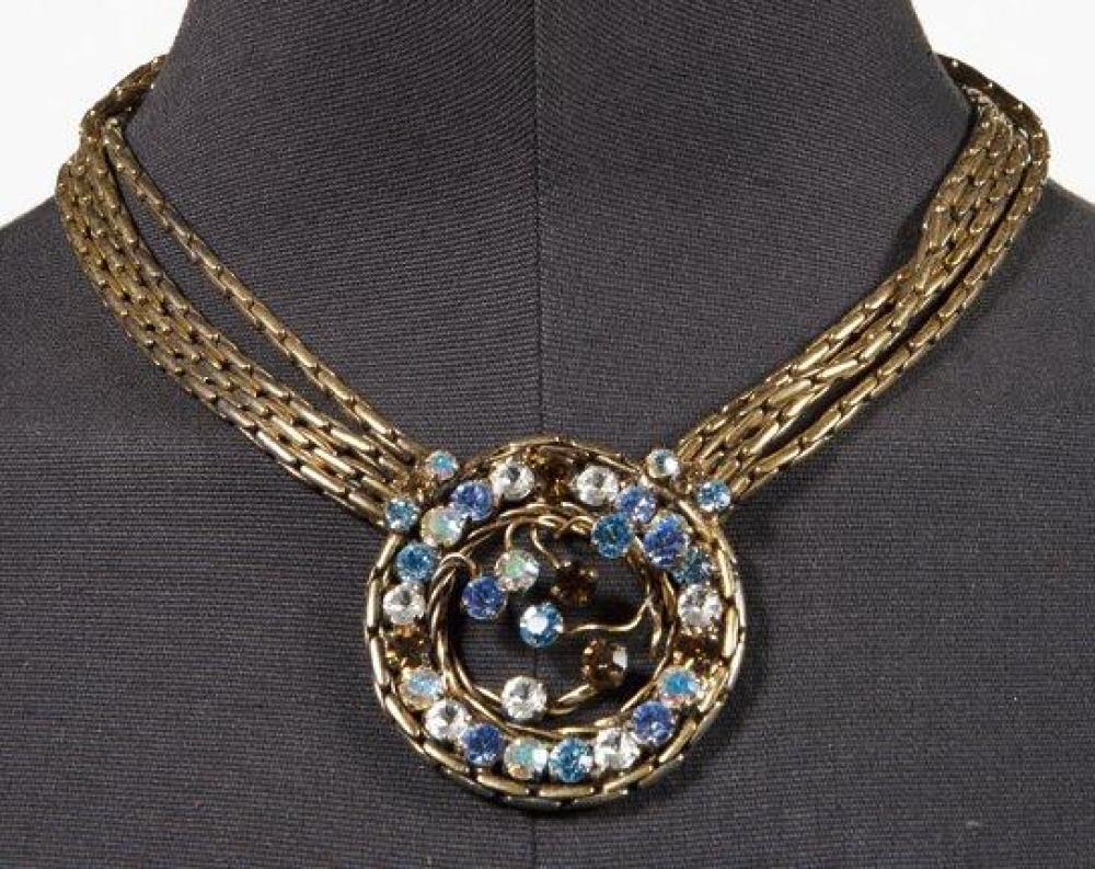 EQUINOX

Collier composé de quatre chaînes à maillons tubulaires retenant un motif circulaire serti de strass multicolore. Signé