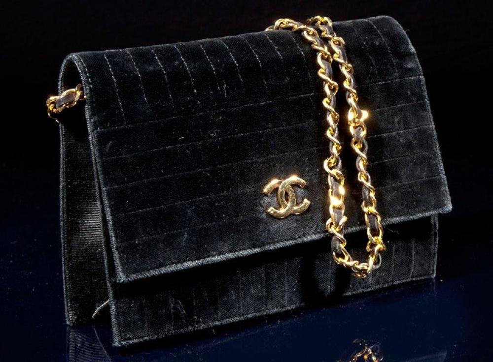 CHANEL

Sac en velours noir surpiqué, fermeture pression siglé sur rabat, anse bandoulière chaîne métal doré entrelacé de velours, bon état