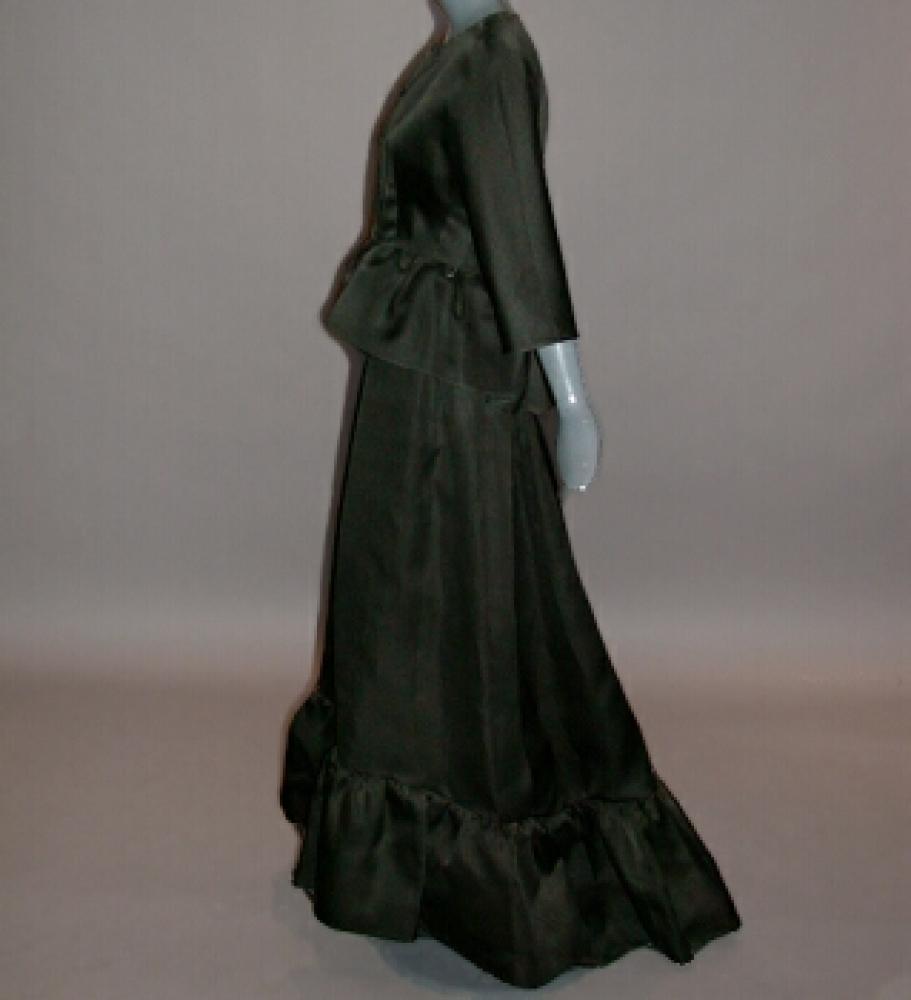 Balenciaga Black Gazar Evening Ensemble

Lot 564
Balenciaga Black Gazar Evening Ensemble
 French, circa 1967 
 Comprising a sleeveless floor length gown with slightly dropped waist, flamenco ruffle at hem, the hem dipping into train at back, and a fitted jacket with similar ruffle at waist, size 6-8, labeled; Balenciaga/10. Avenue George V/Paris and tape label no. 81730.
Very good condition, hooks and eyes and possibly jacket buttons moved, one button missing, minor white speckling on right sleeve.

 Estate of Nina Paris Kronberg
