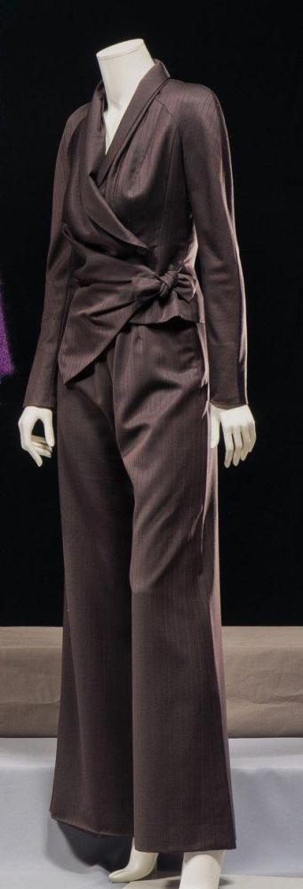 Christian DIOR

Haute couture par John Galliano circa 2004/2005 Ensemble en super 100 marron à fines rayures aubergines sur un fond chevron composé d’une veste à col châle asymétrique et drapé, effet de découpes sur le buste, manches longues raglan, un important drapé revenant sur les hanches pour se nouer sur le côté, bas de la veste découpée, et d’un pantalon rond. Griffe blanche, graphisme noir