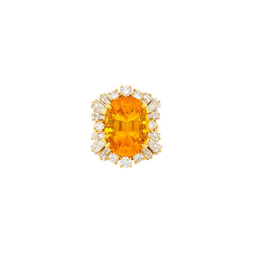A Private Collection18 kt., one oval yellowish orange sapphire weighing 17.37 cts., 8 round and 12 tapered baguette diamonds ap. 3.50 cts., signed Fred Paris, France, with French assay mark, ap. 8.7 dwts. Size 7.
 
With GIA report no. 2231862559 stating heated.

Orange sapphire: bright vivid tangerine orange, very slightly included, one small inclusion, lively.Diamonds: G-H-VS.Width 15/16 inch.                            
Any condition statement is given as a courtesy to a client, is an opinion and should not be treated as a statement of fact and our Organization shall have no responsibility for any error or omission. Please contact the specialist department to request further information or additional images that may be available.