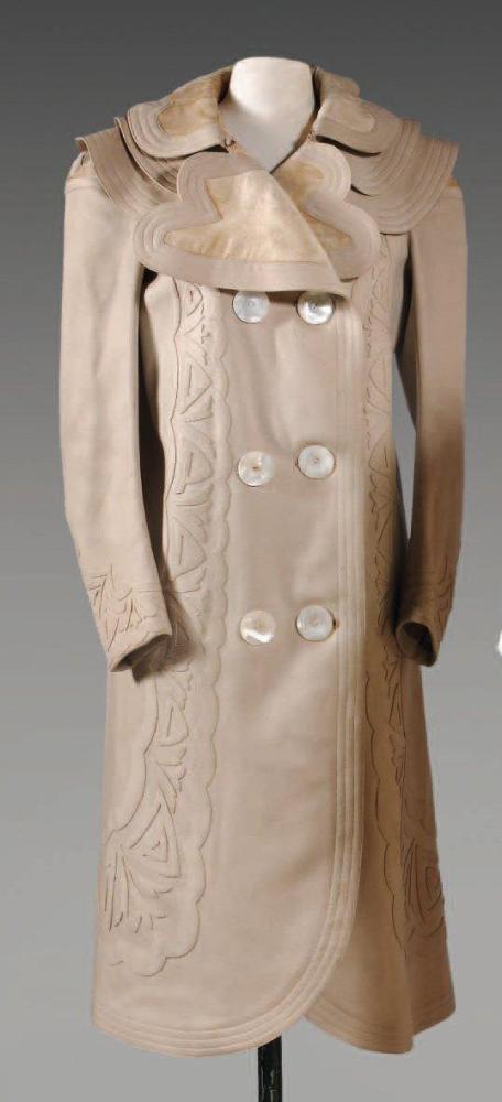 Anonyme

Manteau de voyage pour dame en drap écru, col châle festoné en velours de soie et drap à effet de surpiqûres sur une double petite cape, double boutonnage de nacre rehaussé de motifs végétaux découpés, rappel aux bas manches longues, dos à larges lès ornées de larges surpiqures en applications (mitage, petites usures, manque doublure)