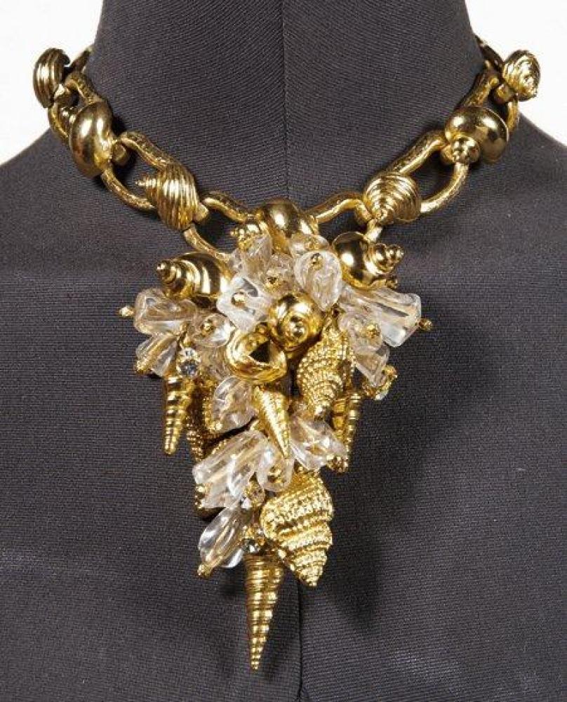 CHRISTIAN DIOR

Magnifique parure en métal doré composée d’un collier en chute, orné d’une multitude de breloques figurant des coquillages rehaussés de motifs en résine translucide façon quartz, monté sur une chaîne à maillons ovales ornés chacun d’un escargot et d’une paire de boucles d’oreille à l’identique. Signé (écrin)