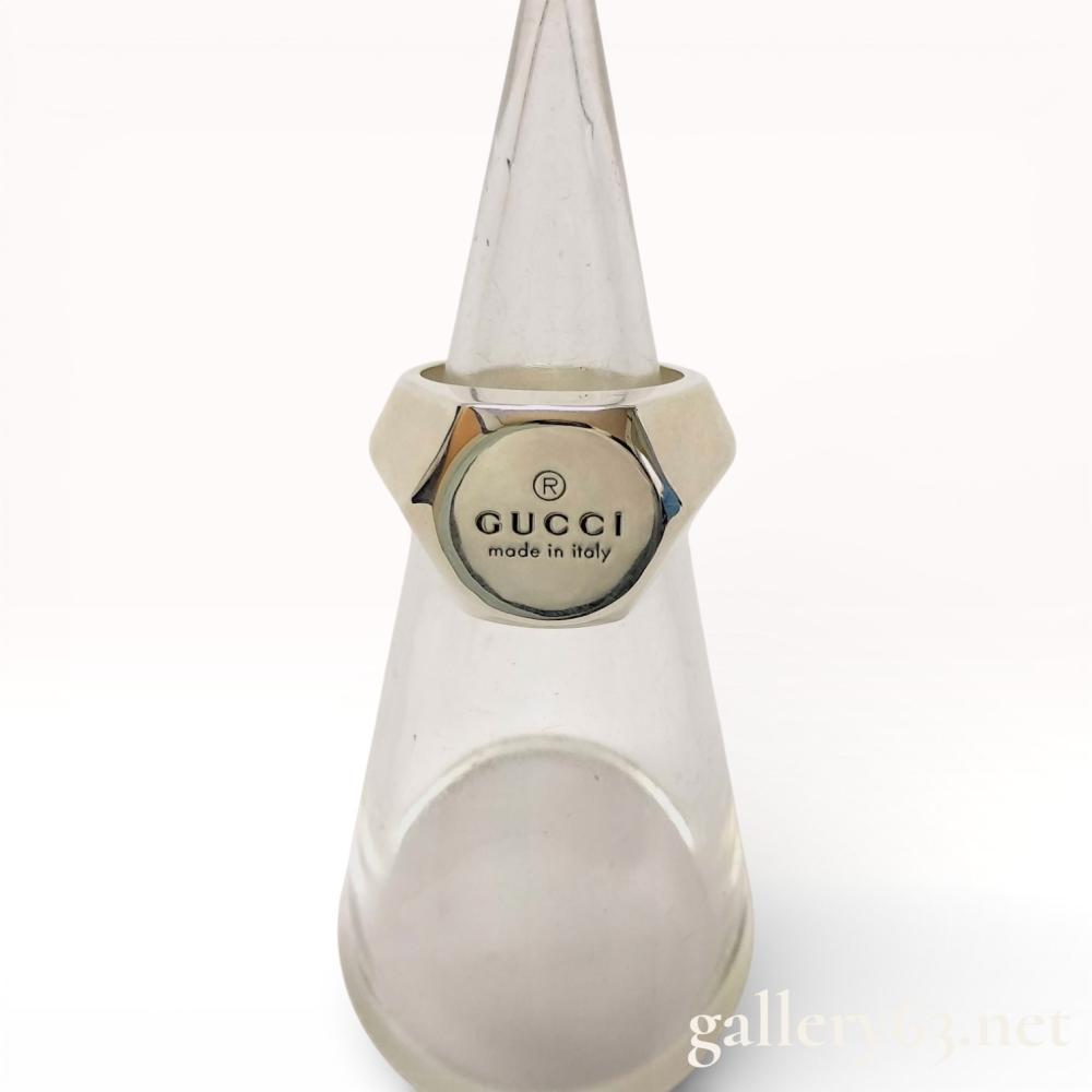 Description
Gucci sterling silver trademark signet ring, modern. The ring features a sculptural hexagonal head with a recessed circular face engraved with the Gucci logo, registered trademark symbol, and made in italy. The interior shank is stamped with the size 17, an Ag 925 purity mark, and Italian workshop hallmarks. Includes a brown textured Gucci presentation box.
European ring size 17 (approximately US size 8).
