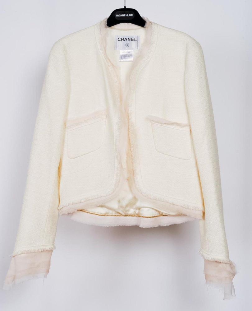 CHANEL

Veste en coton blanc, encolure, parementures, poches, bas et poignets à finition effilochées soulignées de mousseline