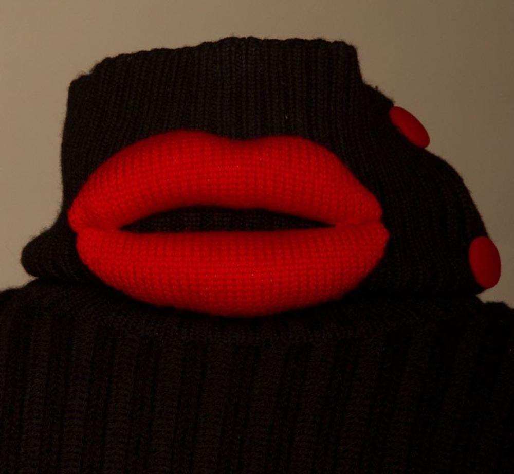 TWO BLACK MOSCHINO GARMENTS, LATE 20TH C

Both size 4 w/ label "Cheap and Chic by Moschino Made in Italy": 1 wool knit high button turtleneck sweater, surreal & luscious padded red knit lips; 1 acetate & rayon skirt w/ double row of corset la