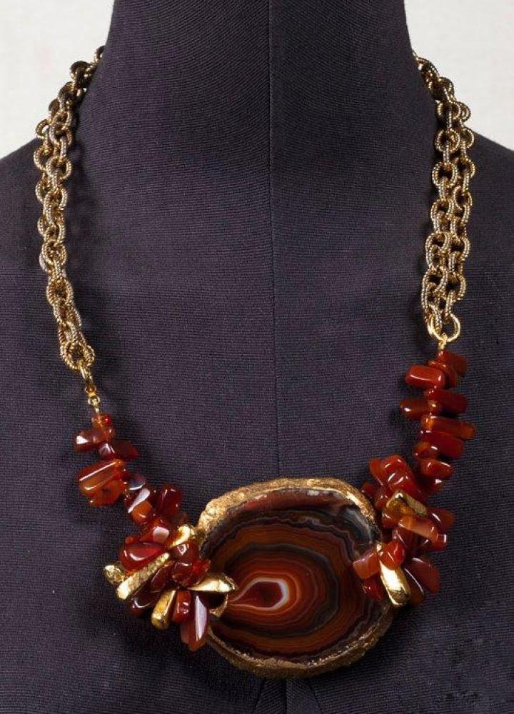 YVES SAINT LAURENT CIRCA 2000

Collier composé d’une importante plaque agate brune, de calcédoines dont certaines peintes or, retenu par une double chaîne de chaque côté à maillons godronnés. Signé par breloques abécédaires
