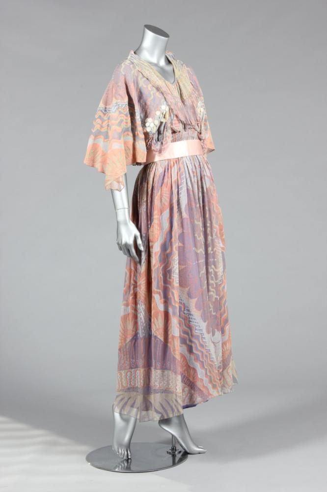 

A Zandra Rhodes Ayers Rock collection evening gown, 1978, labelled, the chiffon printed with Lace Mountain pattern in shades of peach, grey and lilac, with matching pink satin sash and a headband adorned with floret and shell shaped sequins, i bust approx 86-92cm 34-36in (3)



Although the Ayers Rock collection was first presented in 1974, this dress was worn as a bridal gown in 1978.
