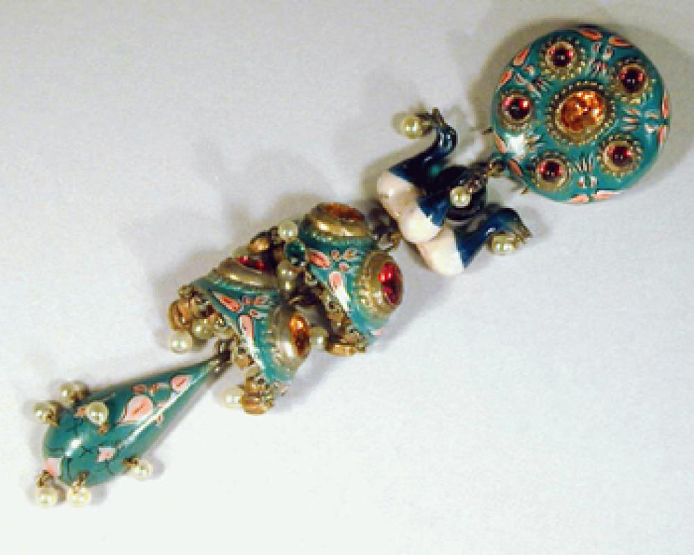 Tiered Drop Pendant

Lot 471
Tiered Drop Pendant
 Possibly Schiaparelli 
 The five-tired pendant of painted enamel on gilt-metal with peacocks and gilt-metal set with red and faux citrine stones and faux seed pearls.