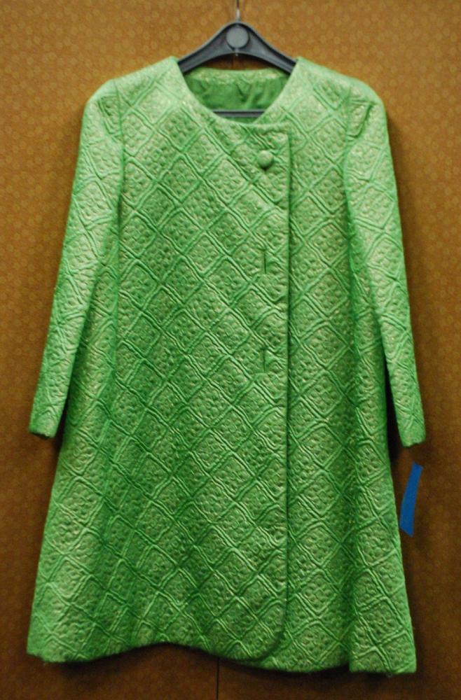 STOP SENES Rome, circa 1966 / 1968

Manteau de cocktail en broché vert et or à effet matelassé de rosaces dans des losanges, encolure ronde, simple boutonnage asymétrique, manches longues. Griffe blanche, graphisme noir