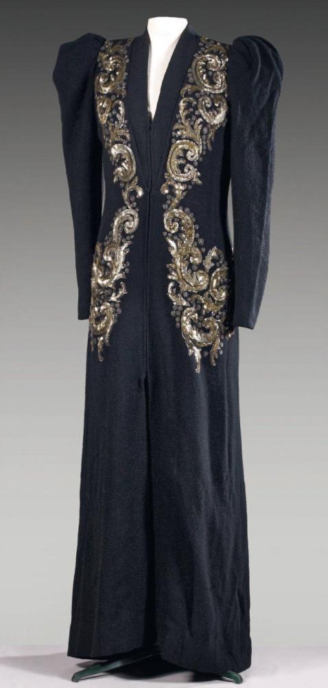 Anonyme

Manteau du soir en lainage noir, devant rebrodé de paillettes et de perles argent et translucides figurant des volutes, encolure montante soulignée d’un biais sur échancrure, manches longues à épaules froncées, devant agrémenté d’une fermeture éclair non d’origine, bas du manteau fluide.
