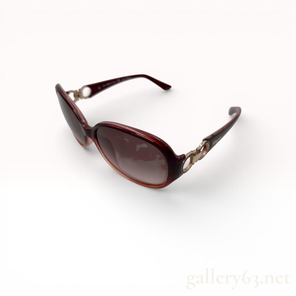 Description
Salvatore Ferragamo SF601S sunglasses featuring deep burgundy acetate frames and brown gradient lenses. The design includes gold-tone metal Gancini logo accents at the hinges and a script logo on the exterior left temple. Interior arms are marked with the model number, color code 607, and Made in Italy.
59mm lens width, 16mm bridge width, 125mm temple length.
